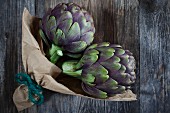 Two artichokes on a wooden table