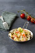 Potato salad with peppers, tomatoes, gherkins and parsley