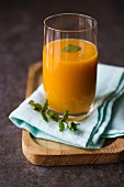 Mango and peach smoothie garnished with mint