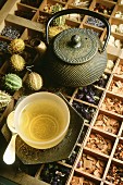 Green tea in a tea bowl on a top of a seedling try filled with herbs and spices