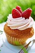 Cupcake mit Buttercreme und Himbeeren