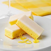 Three slices of lemon cake with icing sugar and lemon zest