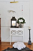 Lantern and ivy arch on Scandinavian side table below magnetic whiteboard with motto