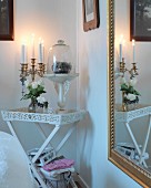 Multi-armed, brass candelabra and decorative glass container on white tray table in corner