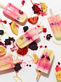 Lemon and berry ice lollies on a white surface