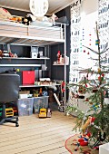 Teenager's metal loft bed with integrated desk; Christmassy curtains with printed lettering and Christmas tree in foreground