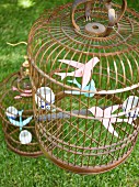 Vogelkäfige mit Papiervögeln als Gartendeko für ein Sommerfest