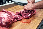 Metzger zerteilt frische Bio-Fleischstücke