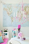 Pink chandelier above vintage-style dining set with vase of peonies