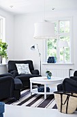 Seating area with black armchairs around round table