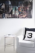 Number printed on scatter cushions on armchair and tray table below photo collage on wall