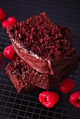 Three slices of chocolate cake and fresh raspberries