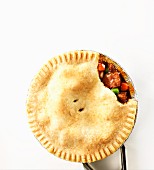 A beef pie with a piece removed