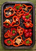 Sliced red peppers on a baking tray