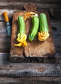 Courgettes with flowers on an old chopping board