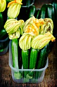 Courgettes with flowers in a plastic box