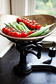 Cherry tomatoes and pea pods on an old pair of kitchen scales