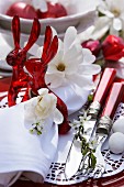 Easter place setting in red and white with rabbit-shaped napkin rings & Magnolia stellata flowers