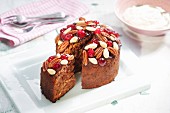 A mini Christmas cake with nuts and glace cherries, sliced