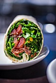 A wrap with lettuce, sausage and tomatoes