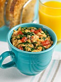Scrambled eggs with tomatoes and spinach served with toast and orange juice