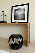 Black and white picture on simple console table and cubic plastic stool