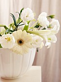 White flowers (lisianthus, gerbera daisies, lilies) in ceramic pot