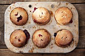 Apple and blackberry pies in a baking tin
