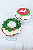 Lemon and chocolate cupcakes decorated with a wreath of holly and a reindeer