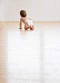 Baby crawling on hardwood floor