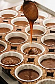 Schokoladenteig in Muffinförmchen füllen