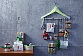 Hand-crafted Advent calender with small parcels hanging from coat hanger on wall