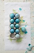 Blau gefärbte Eier in Eierkarton auf Küchenkrepp