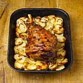 Roasted leg of lamb on a bed of sliced potatoes
