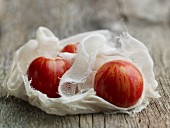 Stripped organic tomatoes in a muslin cloth
