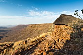 A traditional stone hut with a view into a valley, Namibia