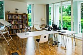 Bright office with designer desks, drawing table and glass sliding doors