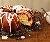 A Bundt cake with raspberries and icing sugar, sliced