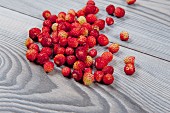 Fresh wild strawberries on a wooden surface