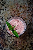 Strawberry and banana smoothie garnished with fresh mint leaves