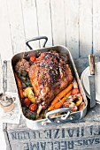 Leg of lamb in a roasting tin with vegetables
