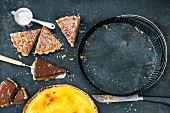 Slices of pine nut tart and chocolate tart with caramel and a whole orange tart
