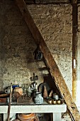 Antique kitchen pots on stone table in old, converted stable