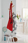 A red knitted shoulder bag on a clothes tree