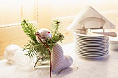 Silver Christmas baubles, fir twigs and fabric love-heart decorating festive buffet