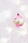Gold and pink Christmas baubles on twisted cord decorated with feathers