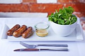 Game sausages with herb salad