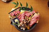 Raw wagyu beef on a bamboo mat with oyster mushrooms (Japan)