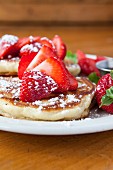 Pancakes with icing sugar and strawberries