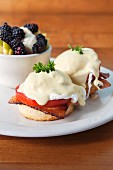 English muffins with poached eggs, tomatoes, bacon and Hollandaise sauce